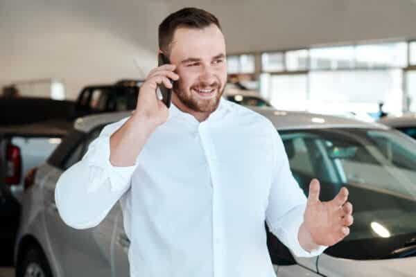 Telefonierender Autoverkäufer im Autohaus