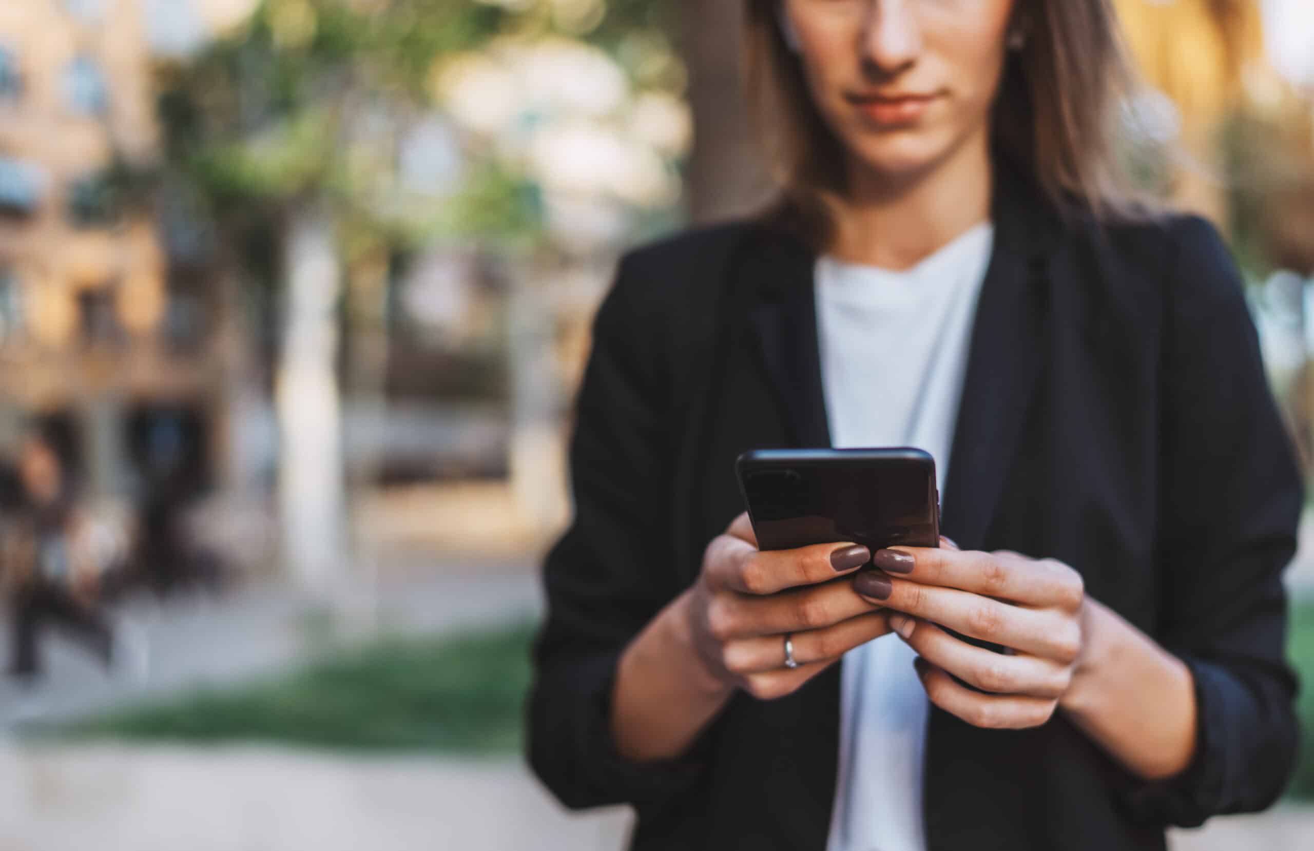 LiveCenter mobile: Geschäftsfrau schaut auf Smartphone in ihrer Hand