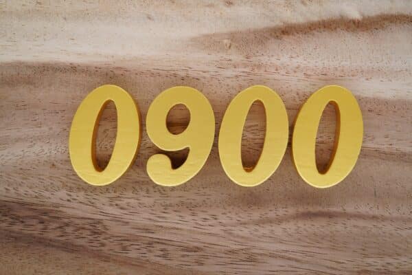0900 Rufnummern: goldene Zahlen 0900 auf Holztisch