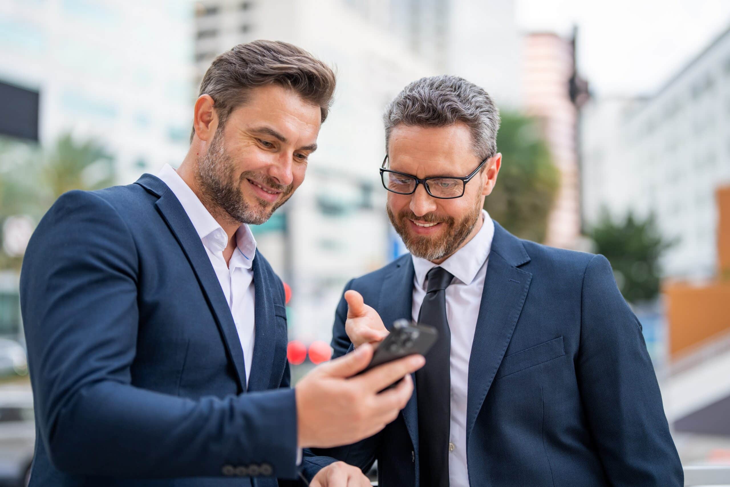LiveCenter mobile: zwei Geschäftsleute schauen gemeinsam auf ein Smartphone